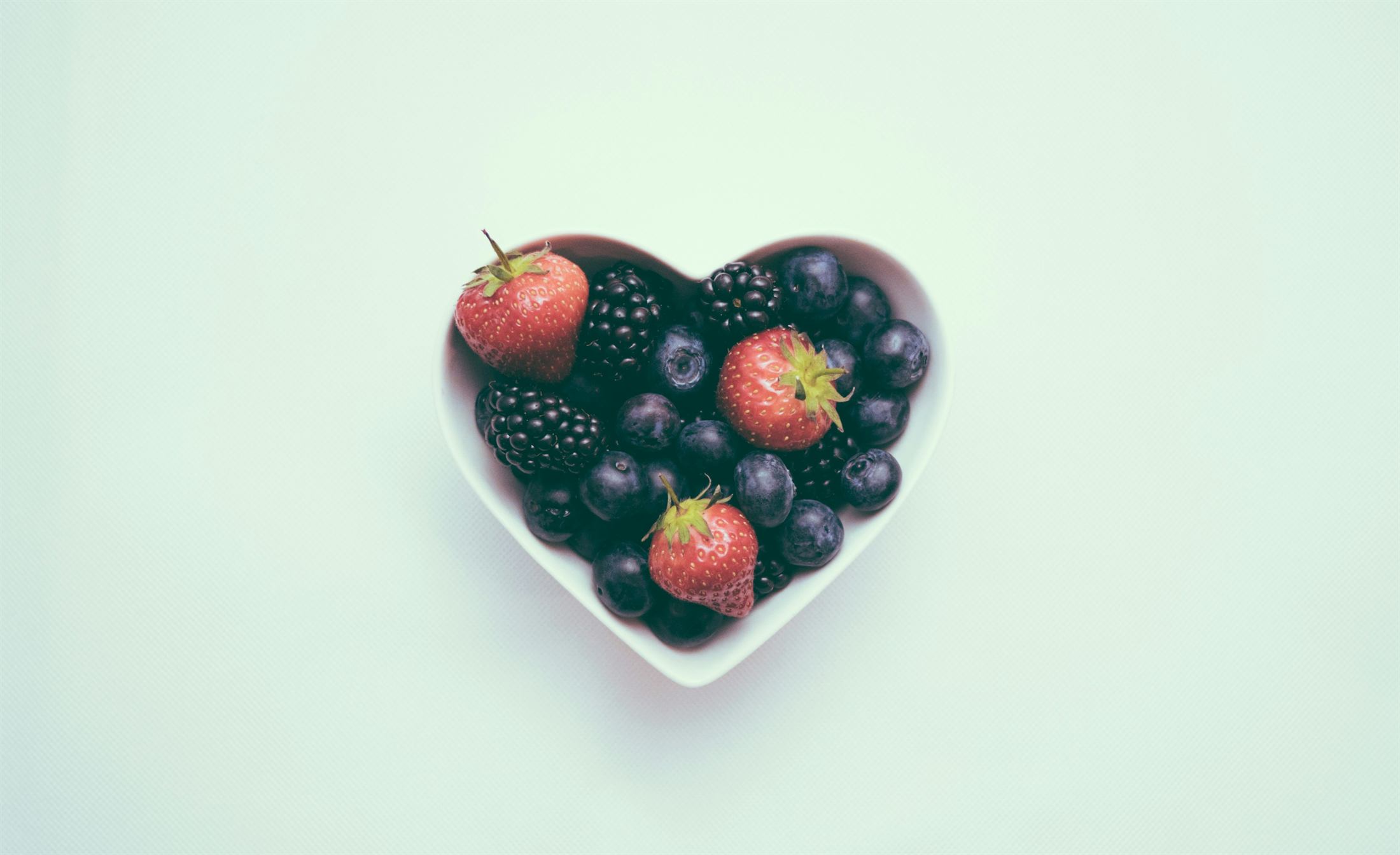 Fresh berries on a soft green background.