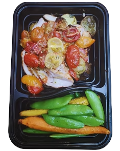 Roasted bruschetta chicken over pesto potatoes with seasonal vegetables in a divided meal container.